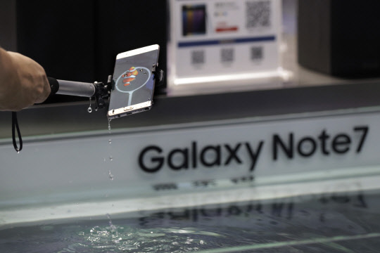 A man tries out the Samsung's latest smartphone Galaxy Note 7 at a roadshow booth outside a shopping mall in Beijing, Thursday, Sept. 1, 2016. Samsung has delayed shipments of Galaxy Note 7 smartphones in South Korea for quality control testing after reports that batteries in some of the jumbo smartphones exploded while they were being charged. (AP Photo/Andy Wong)